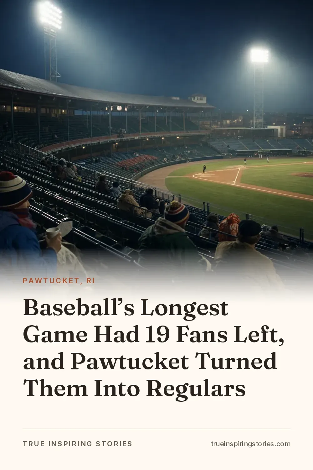 A nearly empty baseball stadium glows under floodlights before dawn with a few bundled fans in the seats.